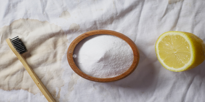 Baking soda and whole lemon on table .