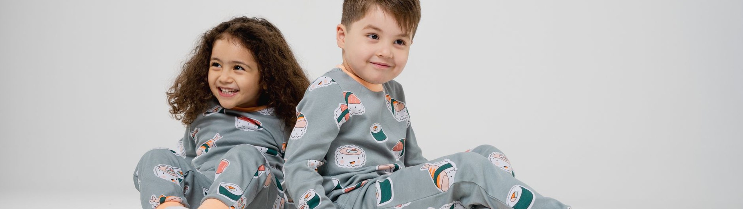 Folded children's pajamas stacked on a shelf, clothing to check before using fabric softener